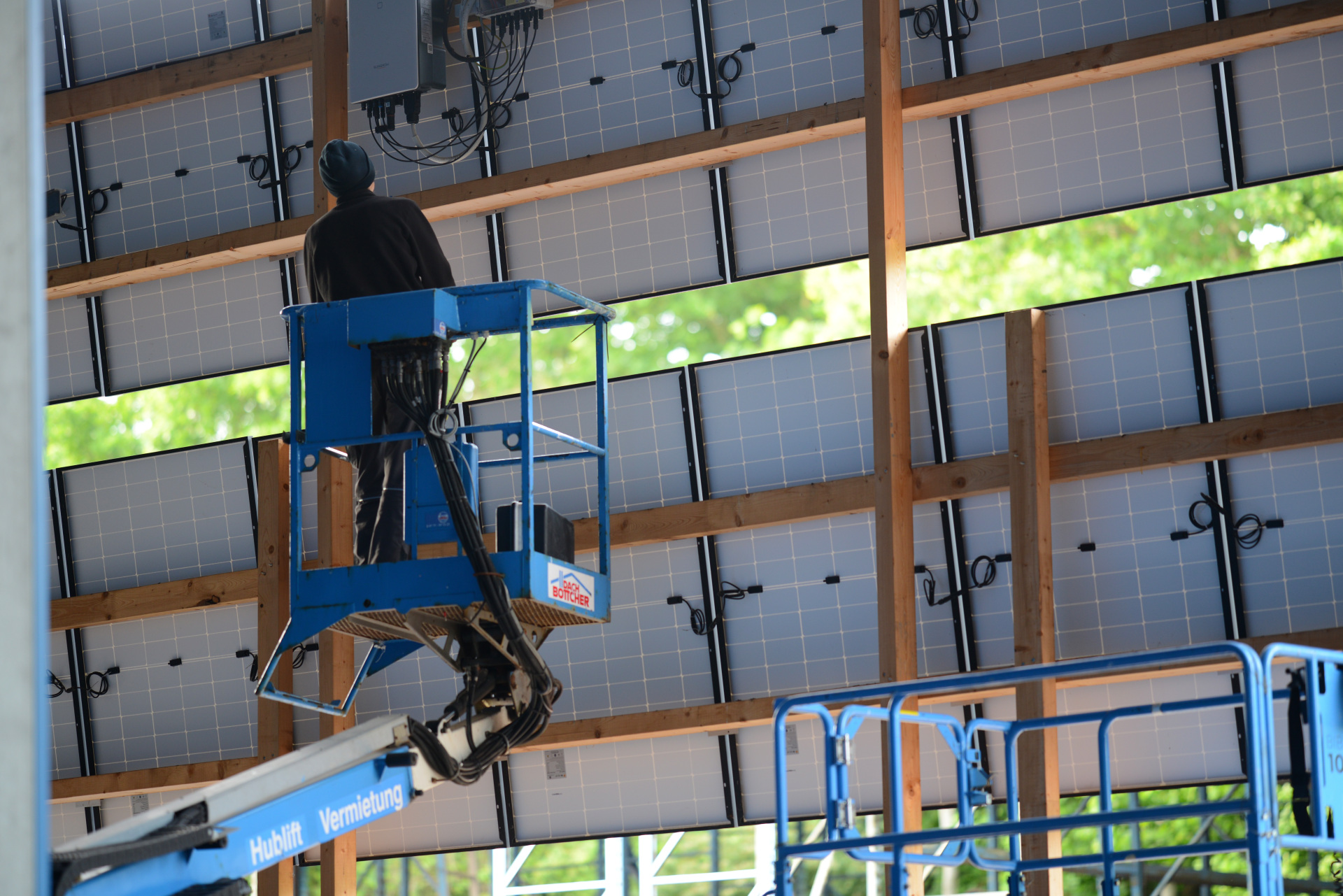 Elektriker auf Hubarbeitsbühne HR12 Nifty Lift vor PV Solar Panels