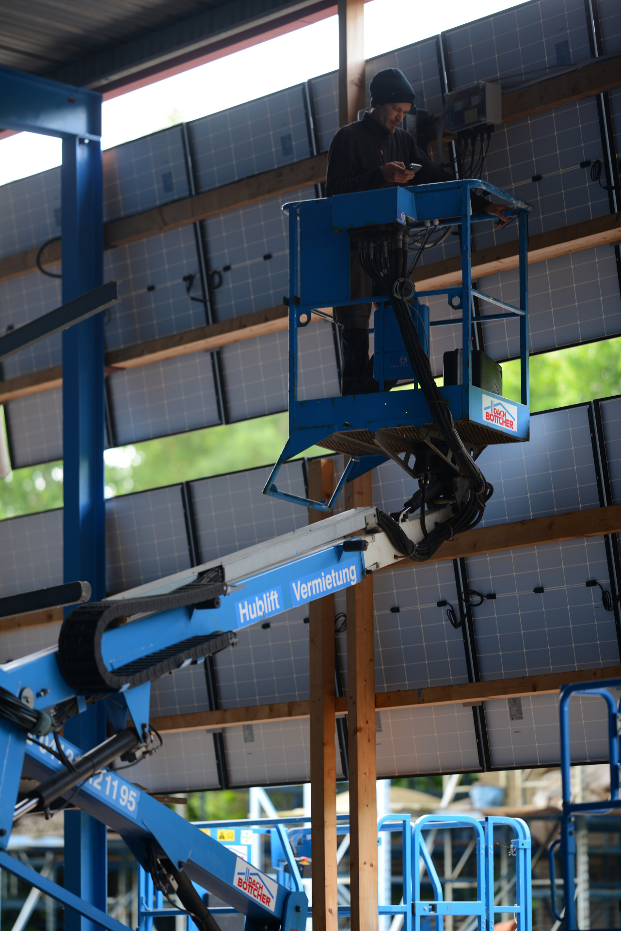 Solar Monteure auf HR12 Nifty Lift vor PV Solar Panels